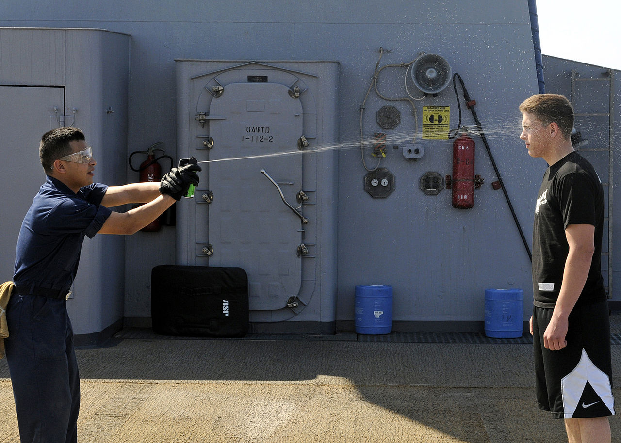 US_Navy_090213-N-7280V-009_Storekeeper_Seaman_Sergio_Torres_sprays_Seaman_Chad_Tomes_with_lemon_juice_to_simulate_getting_spayed_with_Oleor