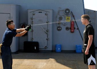 US_Navy_090213-N-7280V-009_Storekeeper_Seaman_Sergio_Torres_sprays_Seaman_Chad_Tomes_with_lemon_juice_to_simulate_getting_spayed_with_Oleor